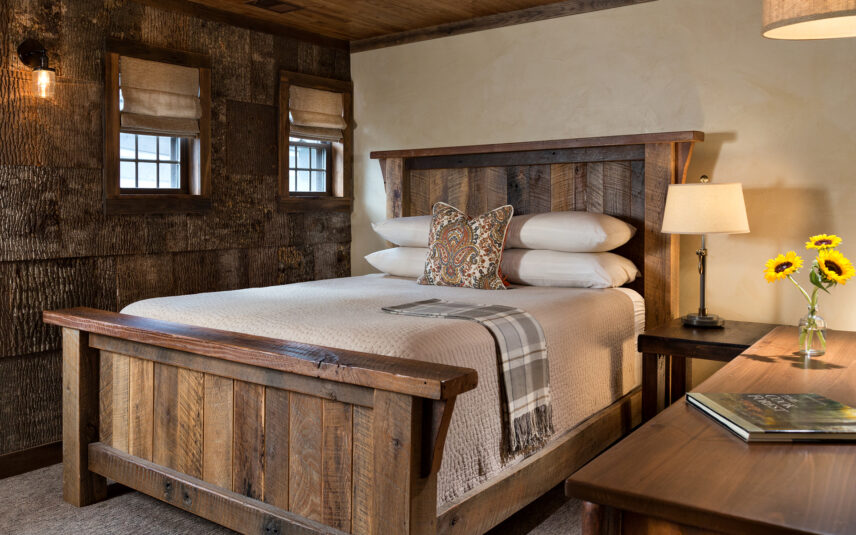 repurposed wooden bed frame with bark walls in background