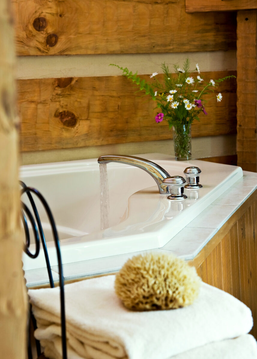Luxurious jetted tub with tiled surround in a Fireside Suite at Gateway Lodge in Cook Forest, Pennsylvania, featuring a clear window view of nature and a cozy atmosphere perfect for relaxation.