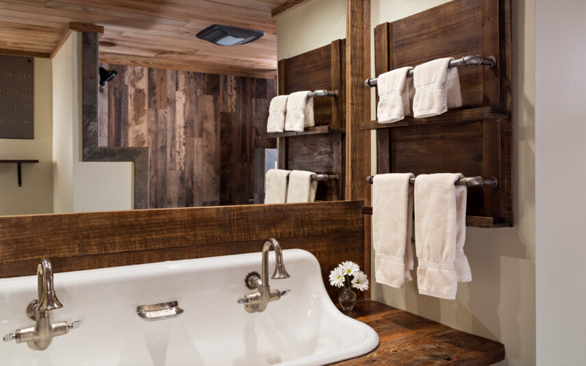 Dual faucet sink and white flowers in a luxury cabin bathroom at Gateway Lodge, Cook Forest PA.