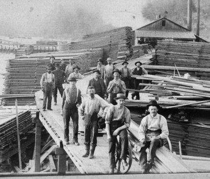 vintage photo of Cook Mill in Cook Forest State Park showing sixteen men gathered in front of lumber