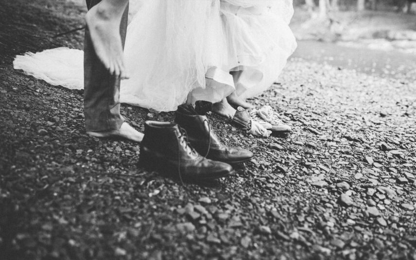 Black and white close-up of wedding couple's feet on river stones at Gateway Lodge elopement, Cook Forest PA.