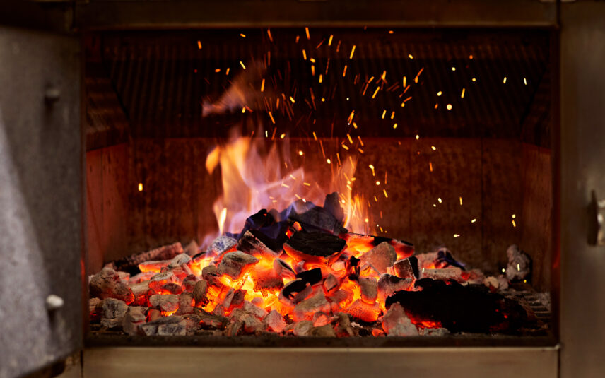 To attract the most people to your website through this image, the best combination of alternative text, title, and description is: Alternative Text (Alt Text): Best Option: Charcoal grill with hot coals, ready for grilling delicious food.
