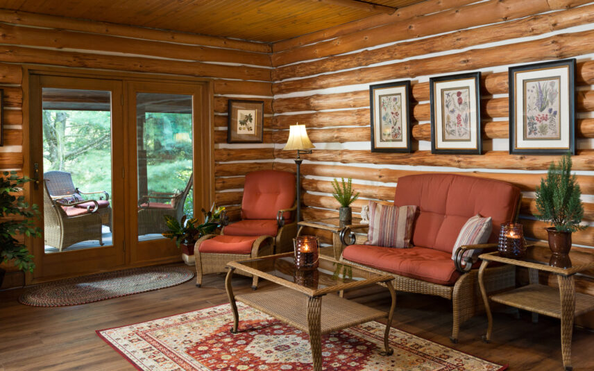 Comfortable seating area within the Forest Meeting Facility at Gateway Lodge in Cook Forest, Pennsylvania, featuring rustic log walls, plush chairs, and a view of the outside porch, perfect for breakout discussions or relaxation during group retreats.