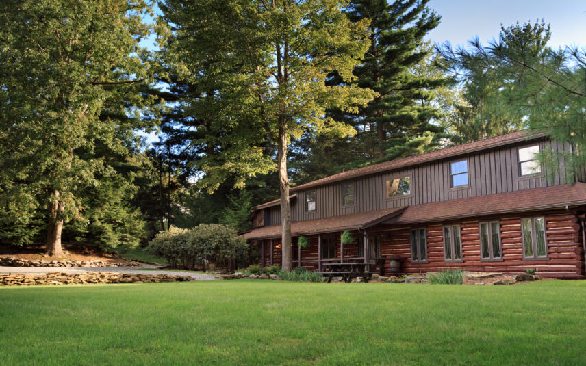Exterior view of the Forest Meeting Facility and Retreat Center at Gateway Lodge in Cook Forest, Pennsylvania, showcasing its rustic wooden architecture nestled in a serene forest setting, ideal for group retreats and events.