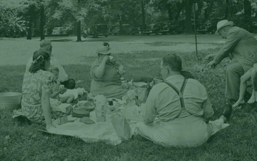Vintage photo of a family enjoying a picnic on a blanket in Cook Forest State Park, Pennsylvania, likely near the Clarion River, a timeless tradition for visitors staying near Gateway Lodge.