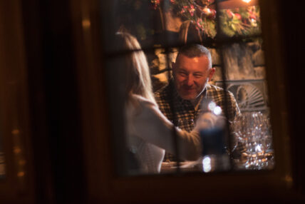 view looking through a windowpane at a man and woman enjoying dinner together at Gateway Lodge restaurant