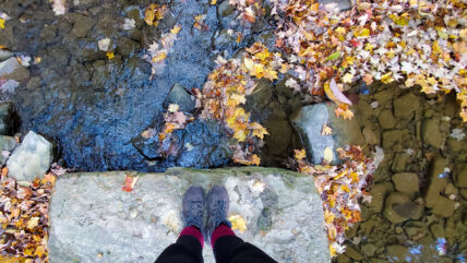 Woman standing on rock in front of river